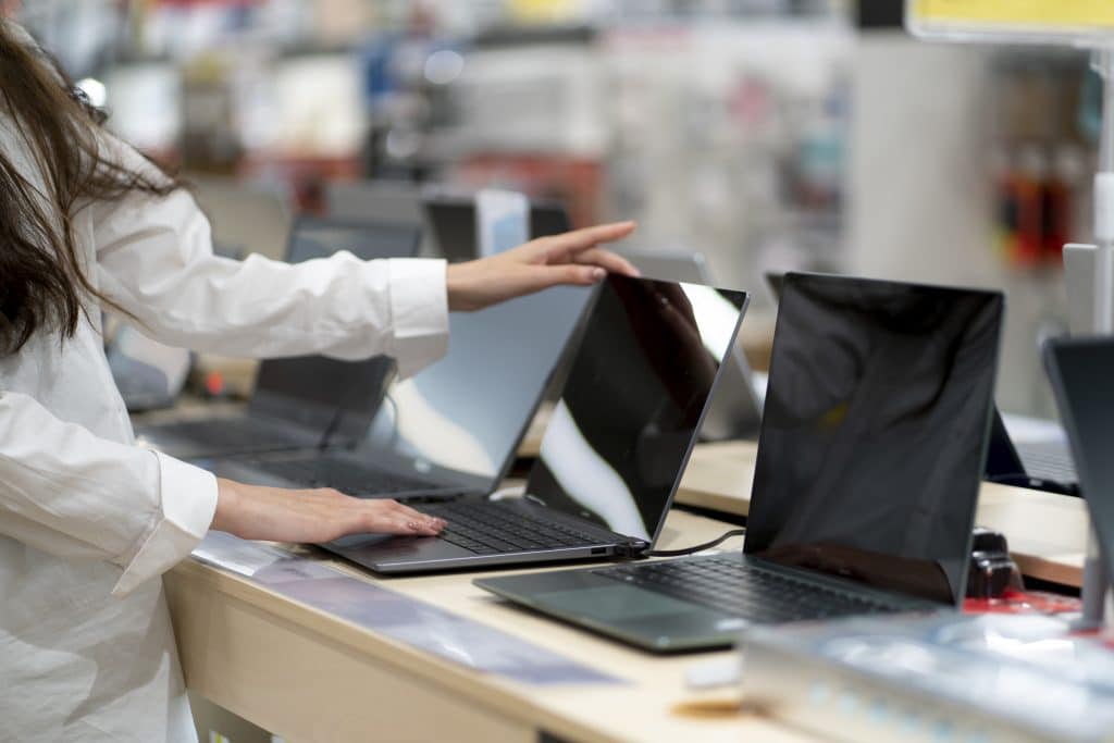 a client in a retail shop choosing a new laptop for studying and working