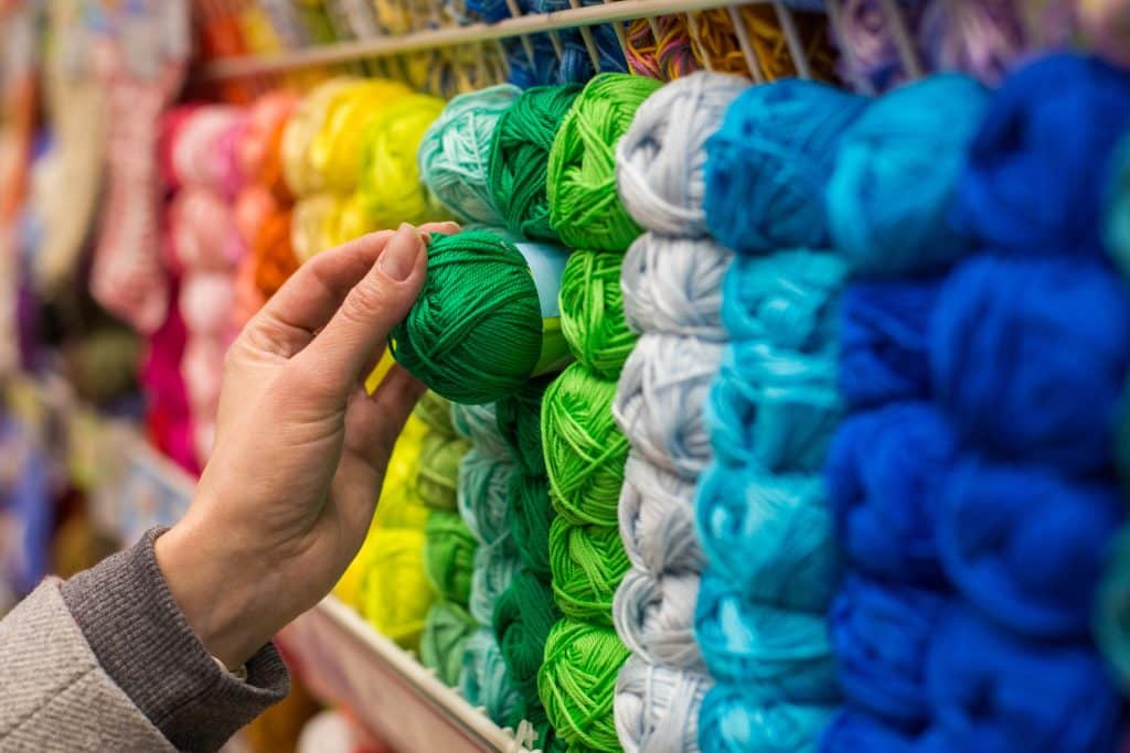 Close Up of yarn balls. Girl hand choosing Yarn in Knitting Shop. knitting shop center.