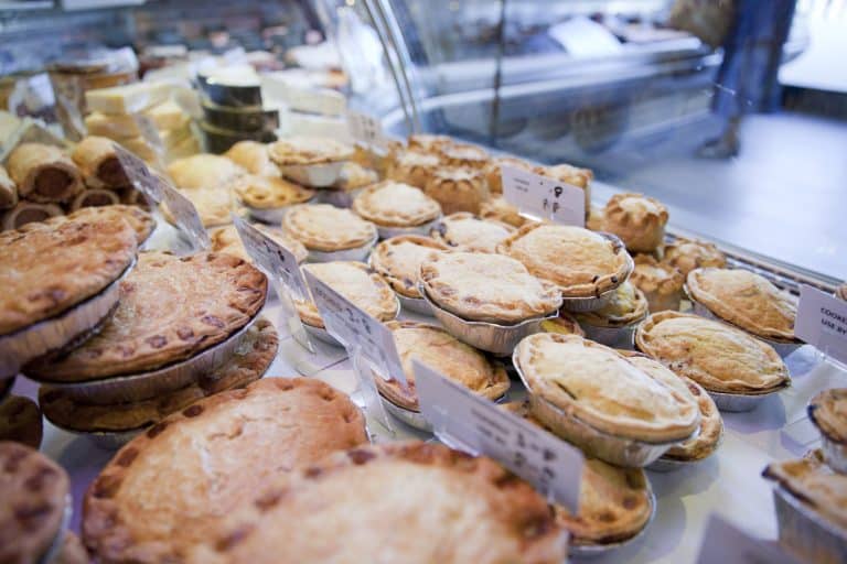 Variety of fresh meat pies in refrigerator at butchers shop